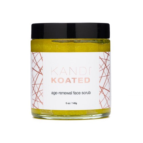 A jar of Kandi Koated Age-Renewal Face Scrub on a white background. The jar has a black lid and a white and rose gold label.