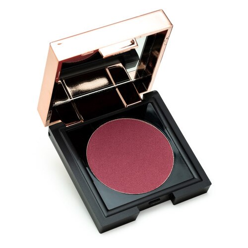 A small black square compact with a rose gold lid containing a mirror sits open, revealing a circle of warm, rich plum powder Chic to Chic blush in “Bashful.”