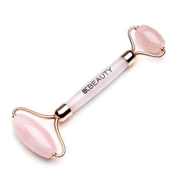 An angled image of the BK Beauty Face the Day rose quartz face roller on a white background