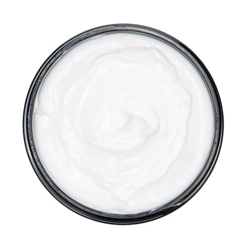 An overhead view of the creamy white contents of the Foot Fetish Moisturizing Cream in a black jar