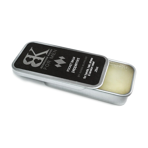 A tin of our BK for Men pocket balm with the lid slid partially off to reveal the balm contained within.