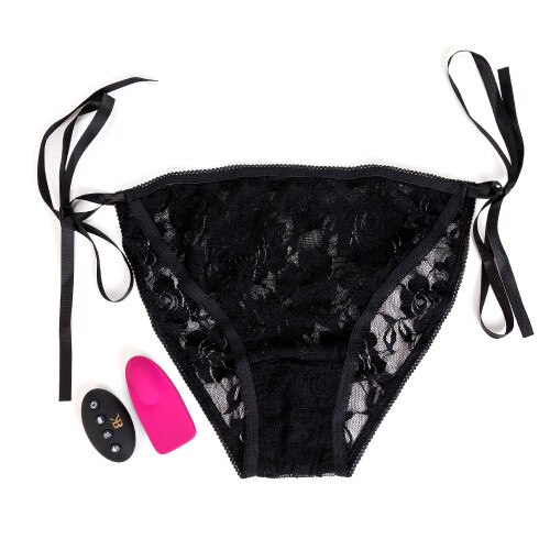 An image of the Bedroom Kandi Groove panty massager, its remote control, and the adjustable one-size black lace panty that it comes with. The panty ties with ribbons at the hips for adjustability.