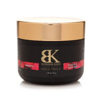 A small black jar with a gold cap of Bedroom Kandi's Kiss and Tingle lip and nipple balm. The label is black and gold with a red stripe indicating the flavor is raspberry.