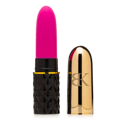 A pink and black Kandi Kisses lipstick shaped vibrator with a gold cap etched with the BK logo beside it