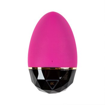 A view of the LUXE collection Entice massager. The massager is egg shaped and pink on top, with a hard black plastic diamond-patterned base outlined by a gold ring. There is a triangular button.