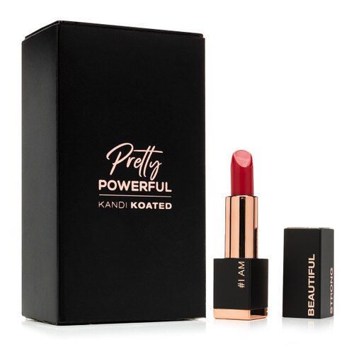 An image of the black Pretty Powerful packaging with rose gold lettering. Beside it is an open tube of Pretty powerful lipstick in “Authentic” with the cap beside it.