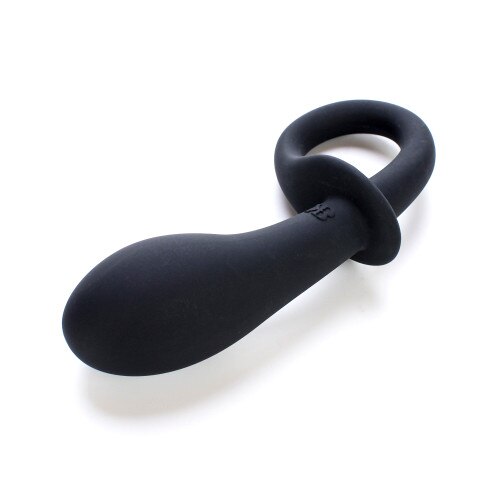 An image of our P-Curious black silicone pleasure plug for prostate stimulation lying on its side. The plug is curved with a base that curls in on itself to form a handle and extraction ring.