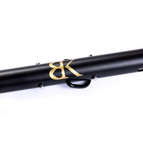 A close up of the center of the SPREAD DESIRE positioning bar featuring the gold BK logo stamped on black metal and a D ring for attachments