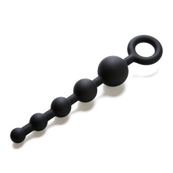 A view of Step-by-Step black silicone anal beads on a white background. The beads are on a flexible rod, growing in size from small to large. There is an easy-grip ring at the base.