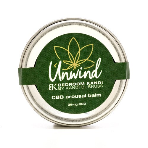 A small round silver tin of Unwind CBD-infused arousal balm with a green label on a white background