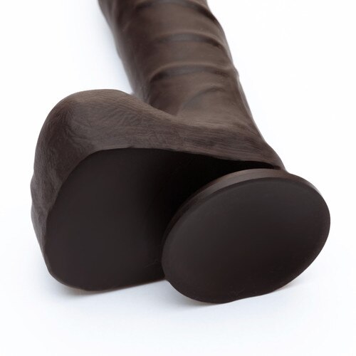A close up view of the suction cup base of the realistic dark brown Vitamin D+ dildo