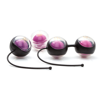 An image of Hold On To Me. It consists of four different weighted Kegel balls. Three of them are in two different silicone holders.