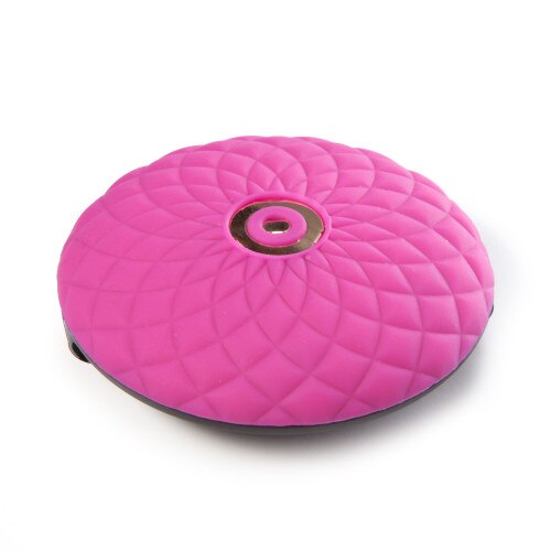 The massager component of Make Me Over sitting face up on a white surface. The front of the massager is elegantly patterned pink silicone in a pleasingly textured surface.